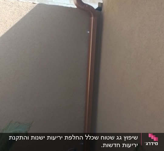 מרזב חום מחובר לגג לבן עם מזגן